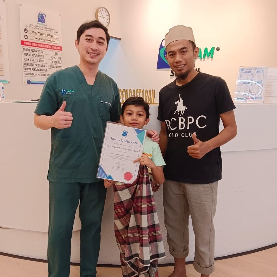 Doktor bersama pesakit kanak-kanak dan ayahnya