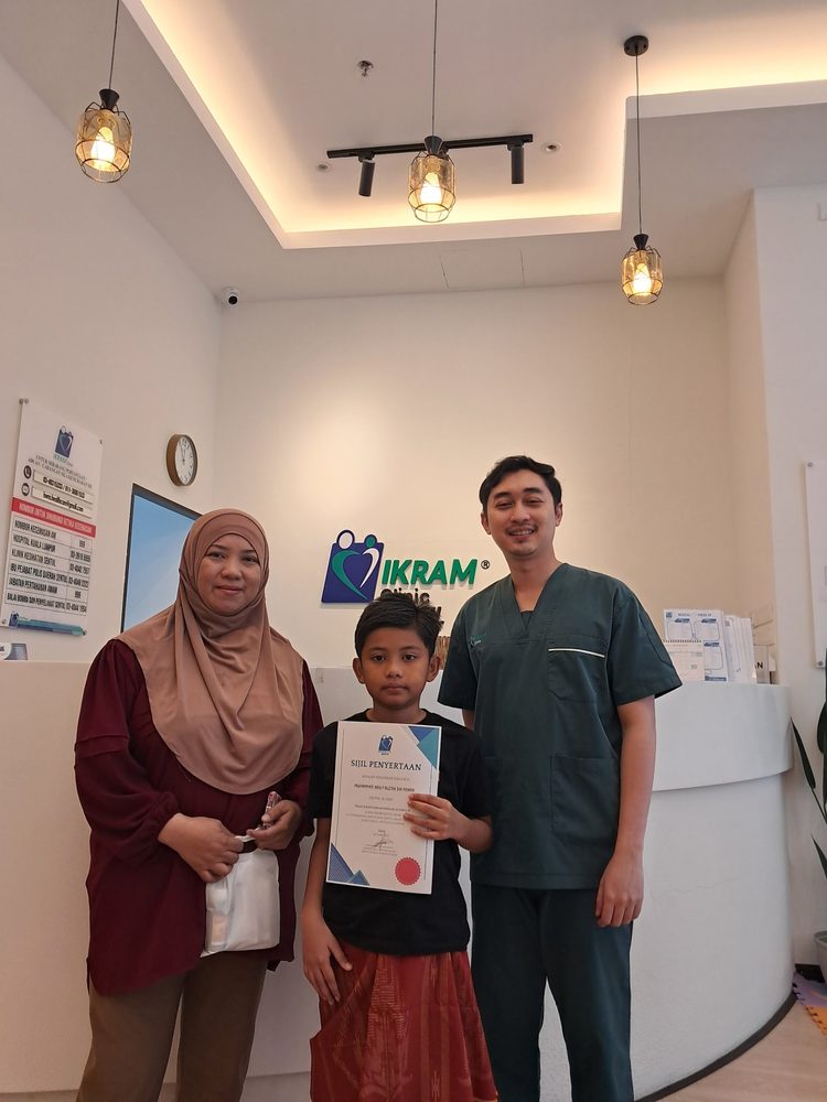 Doktor bersama seorang ibu dan anaknya di kaunter klinik